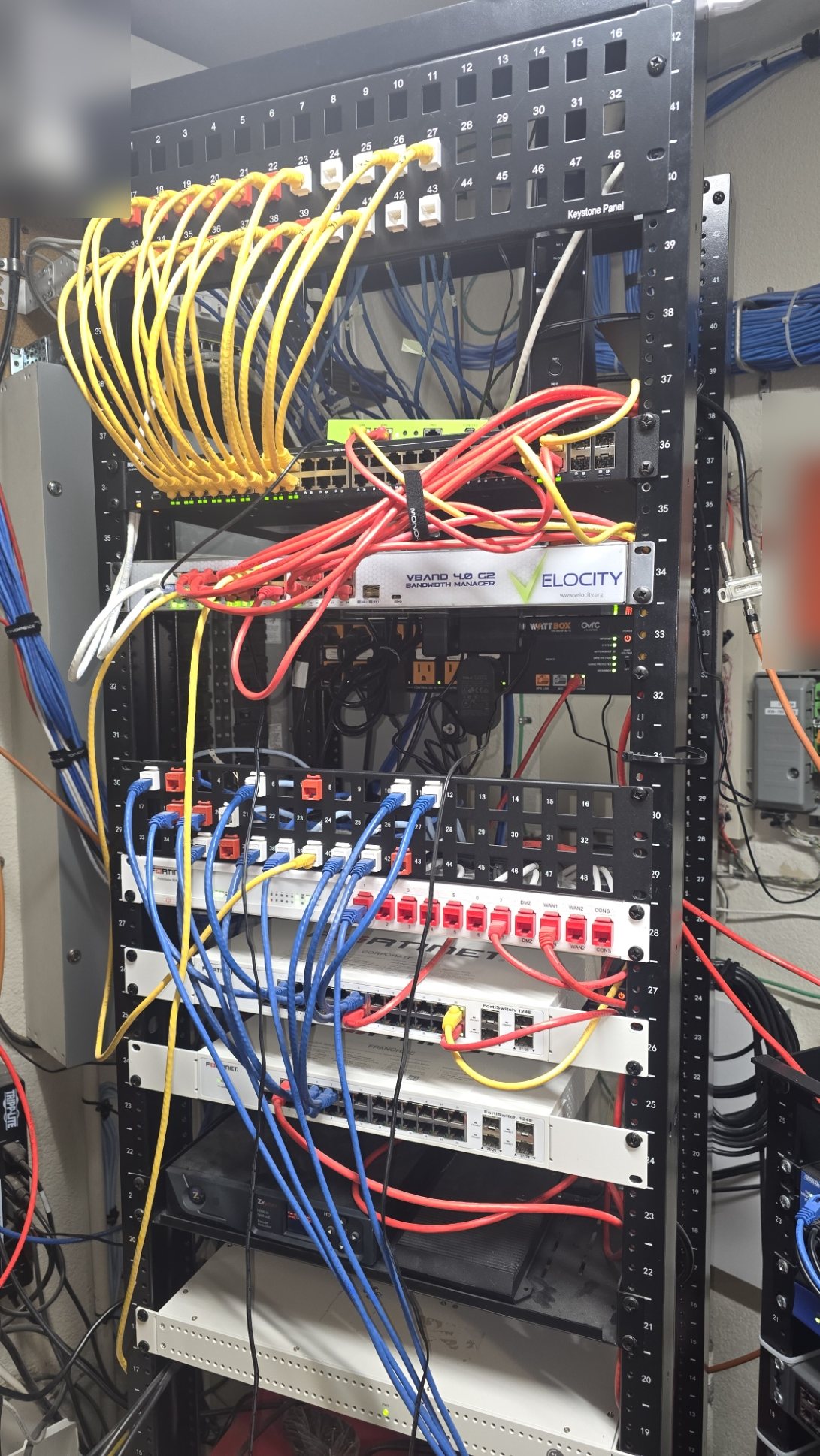 Commercial network rack with AT&T demarc, Velocity bandwidth manager, Fortinet appliances, and structured patching
