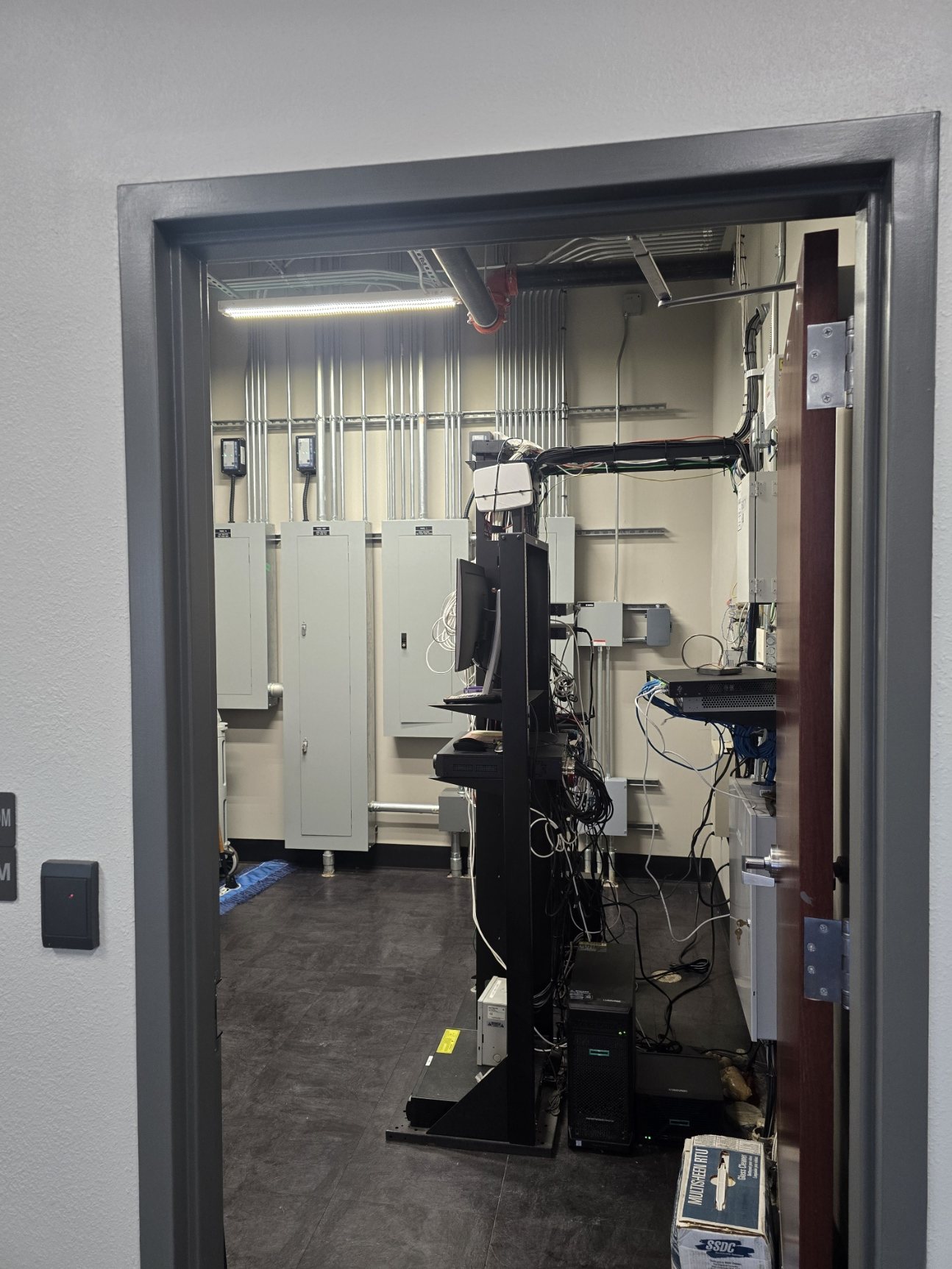 Server room entry and MDF area showing commercial network infrastructure and rack support